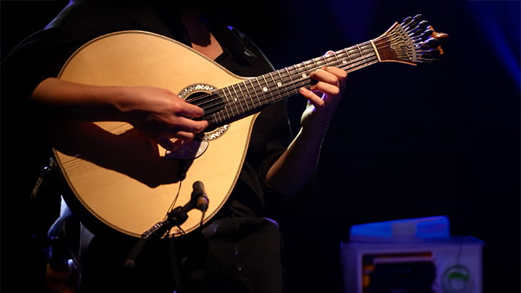 Fado performer playing a tradicional portuguese guitar